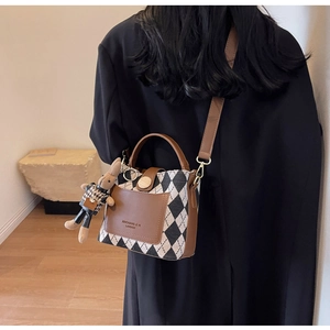 Chic quilted crossbody bucket bag with brown leather trim and cute bunny charm detail