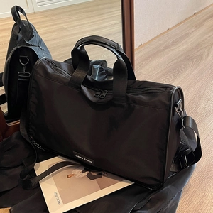 Large capacity black nylon travel bag with crossbody strap and double zipper handles
