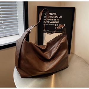 Detail of deep brown large leather Hobo bag with adjustable strap and silver metal buckle