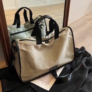 Large capacity beige travel bag with black handles shown in a mirrored lifestyle setting