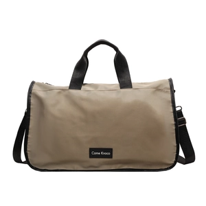 Large khaki waterproof travel duffel bag with black handles and crossbody strap