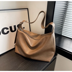Detail of a brown leather Hobo bag with silver zipper and adjustable strap buckle