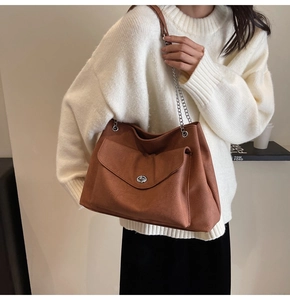 Detail of the brown textured PU leather bag featuring a metal chain strap and twist lock