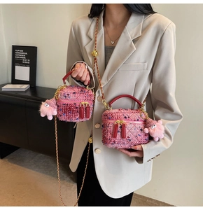 Detail of pink tweed handbag with gold chain strap and cute plush monster charm