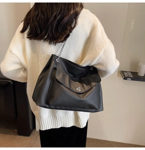 Detailed back view of a black large capacity tote bag with silver chain and twist lock