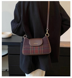 Detail of vintage brown plaid underarm bag with polished gold-tone hardware and leather strap
