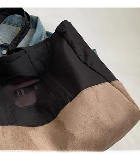 Détails des coutures contrastées et du mélange de matières sur le sac fourre-tout