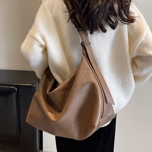 Minimalist large brown hobo tote bag in soft PU leather shown in a stylish lifestyle setting