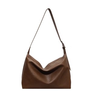 Large brown leather tote bag with a textured finish and adjustable shoulder strap for daily use