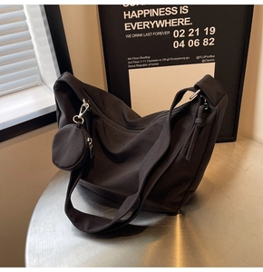 Détail du sac dumpling noir en nylon avec mini porte-monnaie amovible et bandoulière large