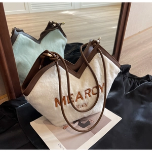 Detail der weißen Plüschtasche mit braunem Lederbesatz und Mearoy Italy Stickerei