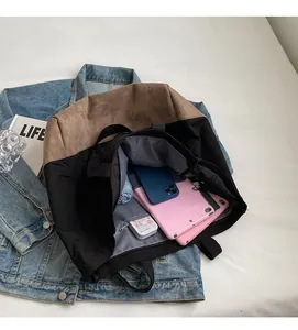 Intérieur spacieux du cabas en toile bicolore contenant un parapluie et une tablette