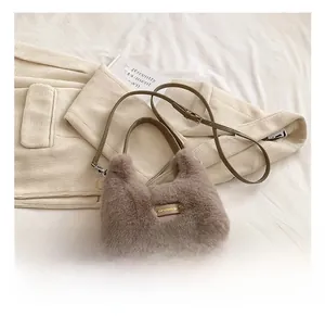 Detail of plush brown-grey faux fur shoulder bag with gold metal 'love every day' plaque