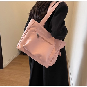 Close-up of pink high-capacity canvas tote bag with front zipper pocket and dual handles