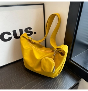 Détail d'un sac à bandoulière en toile jaune vif avec un mini porte-monnaie assorti
