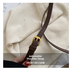Detail of adjustable dark brown leather shoulder strap with a polished gold buckle