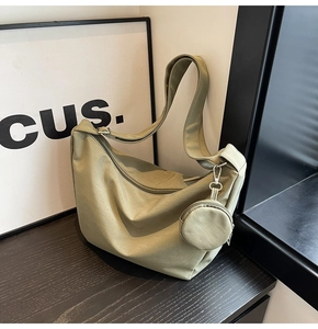 Détail du sac hobo en toile vert olive avec sa petite pochette ronde assortie amovible