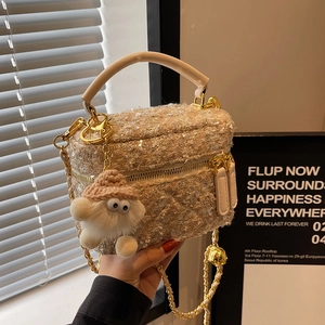 Chic tweed crossbody bag with sequins and a cute plush monster charm in a stylish setting