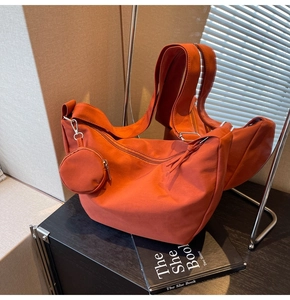 Détail du sac hobo rouge brique avec large bandoulière et mini porte-monnaie assorti