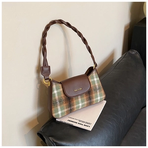 Detail of vintage plaid underarm bag featuring a brown leather woven strap and logo