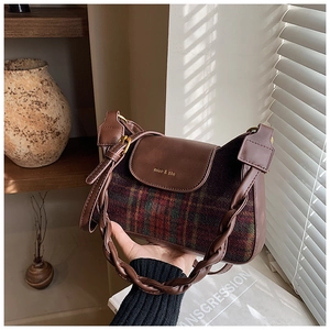 Detail of vintage brown plaid bag with woven handle and premium leather texture