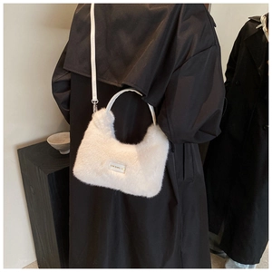Gros plan du sac en peluche blanc avec poignées en cuir et étiquette love every day