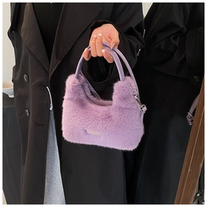 Close-up of purple faux fur handbag with 'love every day' tag and metal strap buckles