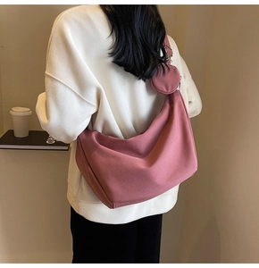 Détail du sac bandoulière en toile rose poudré avec pochette ronde et fermeture éclair
