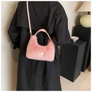 Détail du sac à main rose en fausse fourrure avec bandoulière et poignée élégante