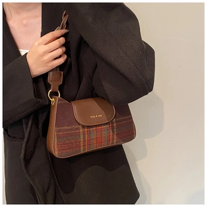 Detail of vintage brown plaid shoulder bag with cat-ear design and gold logo on flap