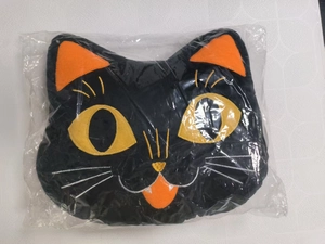 Detail of black cat plush pillow with vibrant orange ears and yellow eyes for Halloween