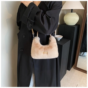 Détail du sac hobo en fausse fourrure pelucheuse avec plaque en métal et bandoulière
