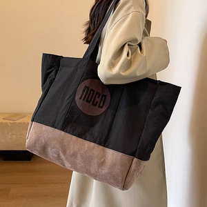 Grand sac cabas noir en toile avec fond en daim marron et logo NOCO sur un mannequin
