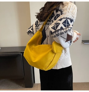 Détail du sac messager en toile jaune avec bandoulière réglable et porte-monnaie rond