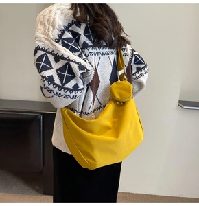 Détail du sac croissant en toile jaune vif avec un petit porte-monnaie rond assorti