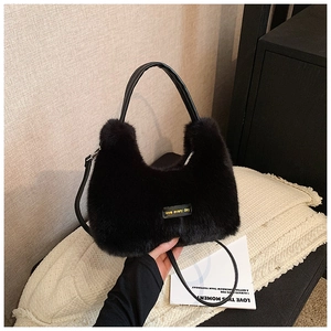 Détail du sac à main en fausse fourrure noire avec étiquette et poignée en cuir