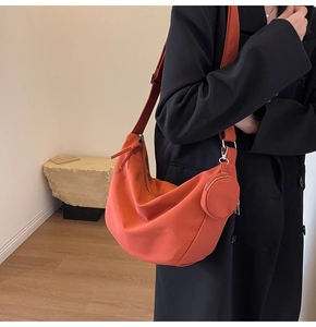 Détail du sac bandoulière croissant orange avec son mini porte-monnaie assorti