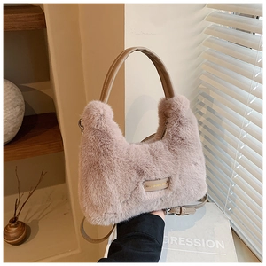 Détail d'un sac à main en peluche mauve avec poignée en cuir et bandoulière réglable