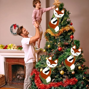 Set di tre calze di Natale volpe con decorazioni di pino in scena familiare