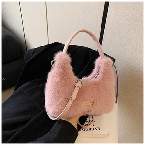 Détail du sac à main en fausse fourrure rose avec plaque en métal et sangle en PU
