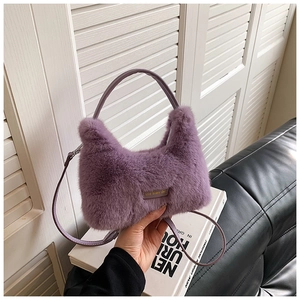 Détail d'un sac à main en fausse fourrure violette avec texture douce et étiquette cuir
