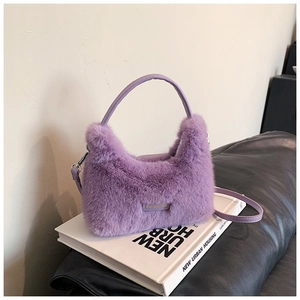 Détail du sac à main en fausse fourrure violette avec étiquette cuir et métal argenté