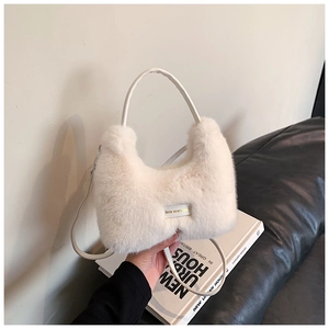 Détail du sac à main en fausse fourrure blanche avec étiquette dorée love every day