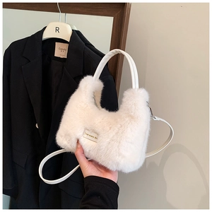 Détail d'un sac en peluche blanc avec poignée ronde et étiquette love every day
