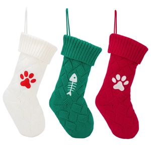 Set di tre calze natalizie in maglia con ricami di impronte di animali e lische di pesce