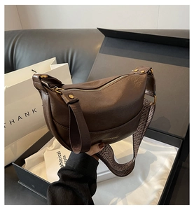 Détail du sac bandoulière en similicuir marron avec sangle tissée à chevrons vintage