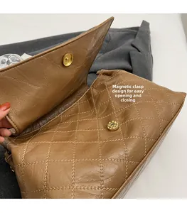 Détail de la fermeture magnétique et du matelassage sur le sac bandoulière marron