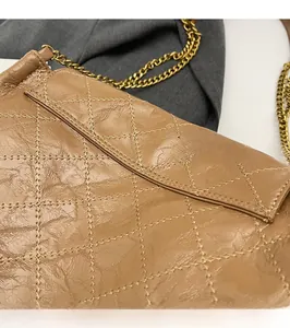 Gros plan sur le sac en cuir matelassé marron avec surpiqûres fines et chaîne dorée