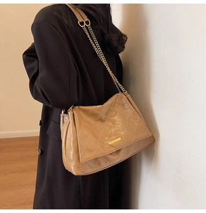 Gros plan du sac matelassé kaki avec barre métallique polie et texture simili cuir