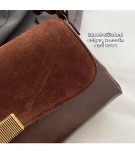 Detail of handcrafted stitching on brown suede and burgundy leather underarm bag